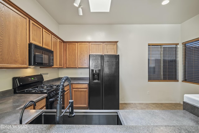 kitchen with light tile patterned floors, sink, and black appliances