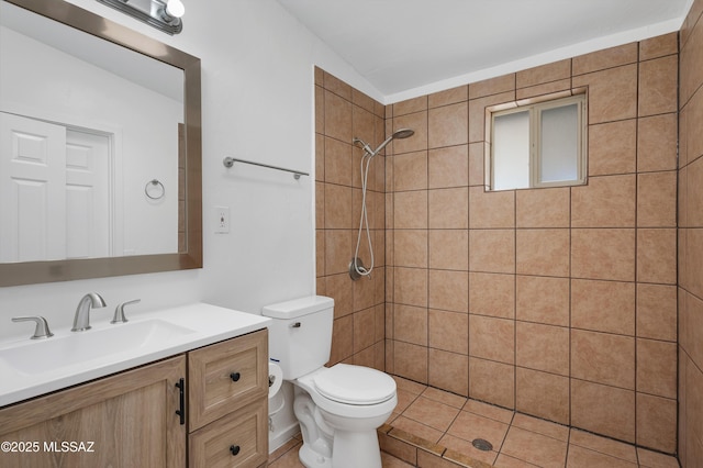 bathroom featuring tiled shower, vanity, and toilet