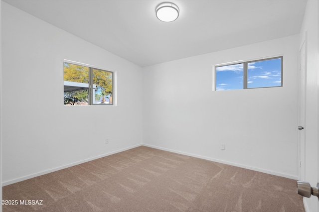 spare room with vaulted ceiling and carpet floors