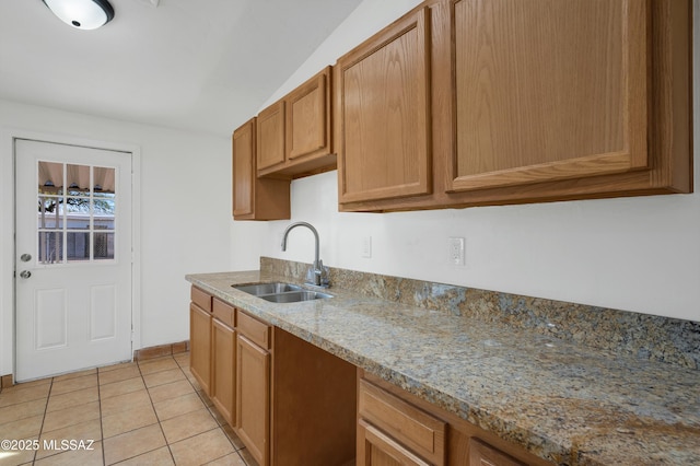 kitchen featuring light stone counters, light tile patterned flooring, and sink