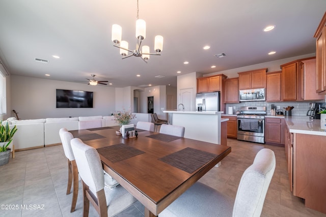 dining room featuring light tile patterned flooring and ceiling fan with notable chandelier