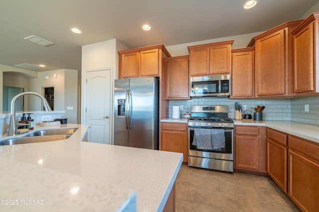 kitchen featuring stainless steel appliances, sink, decorative backsplash, and light tile patterned floors