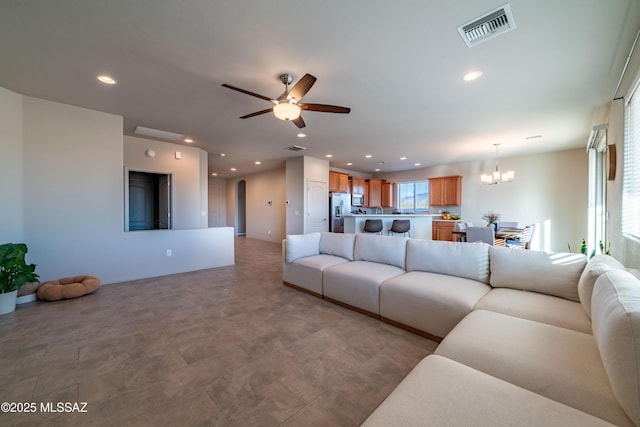 living room with ceiling fan with notable chandelier