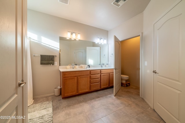 bathroom featuring vanity, tile patterned floors, and toilet