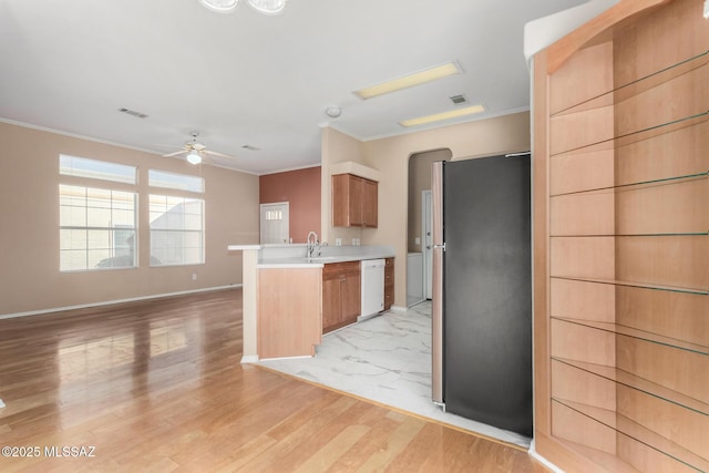 kitchen with dishwasher, stainless steel fridge, kitchen peninsula, crown molding, and light wood-type flooring