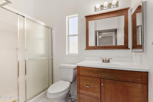 bathroom with vanity, toilet, and a shower with door