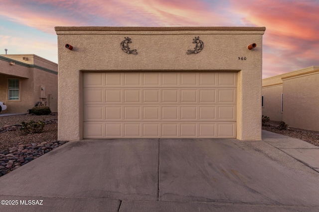 view of garage at dusk