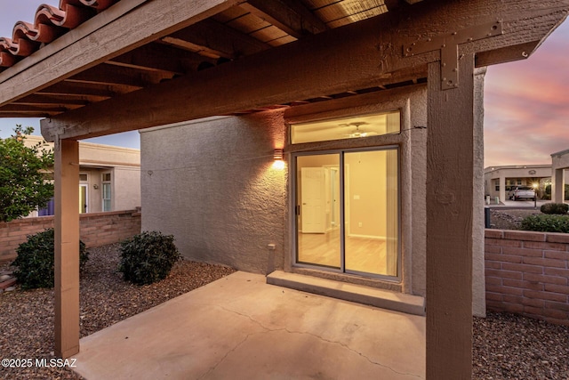 exterior entry at dusk with a patio area