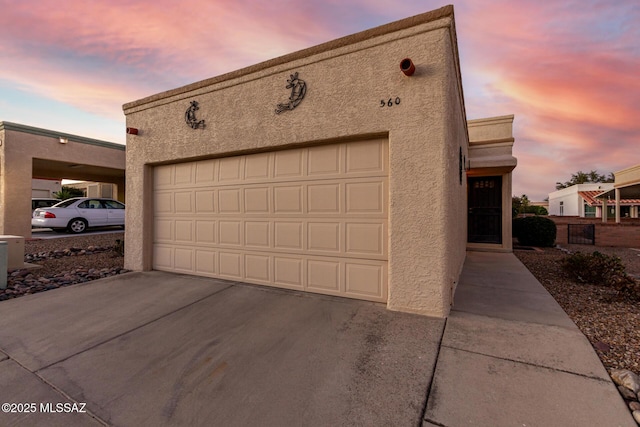 view of garage at dusk