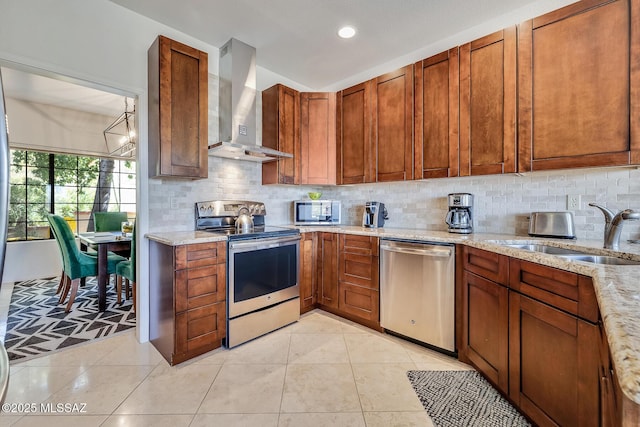 kitchen featuring sink, appliances with stainless steel finishes, backsplash, light stone countertops, and wall chimney exhaust hood