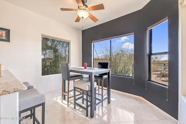 tiled dining room featuring a wealth of natural light and ceiling fan