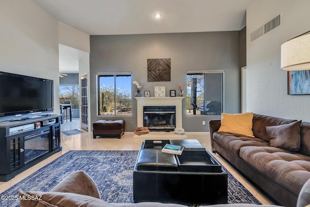 tiled living room with a towering ceiling and plenty of natural light