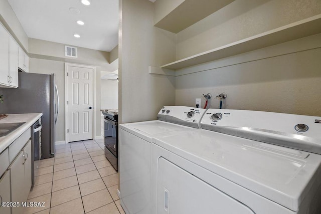 washroom with ceiling fan, sink, light tile patterned floors, and independent washer and dryer