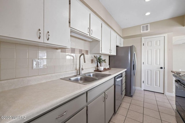 kitchen with sink, white cabinetry, light tile patterned floors, dishwasher, and backsplash