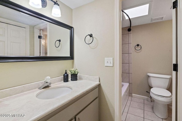 full bathroom featuring tile patterned flooring, a skylight, vanity, toilet, and tiled shower / bath