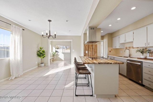 kitchen featuring sink, white cabinetry, island range hood, hanging light fixtures, and dishwasher