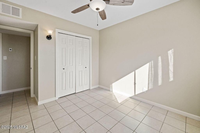 unfurnished bedroom with ceiling fan, a closet, and light tile patterned floors