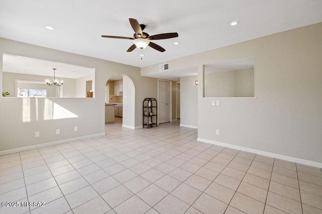 spare room with light tile patterned flooring and ceiling fan with notable chandelier