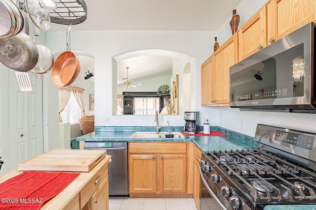 kitchen featuring sink, light tile patterned floors, stainless steel appliances, and ceiling fan