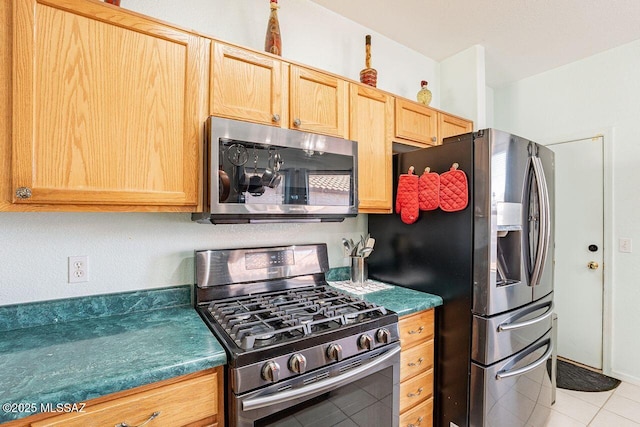 kitchen featuring light tile patterned flooring and appliances with stainless steel finishes