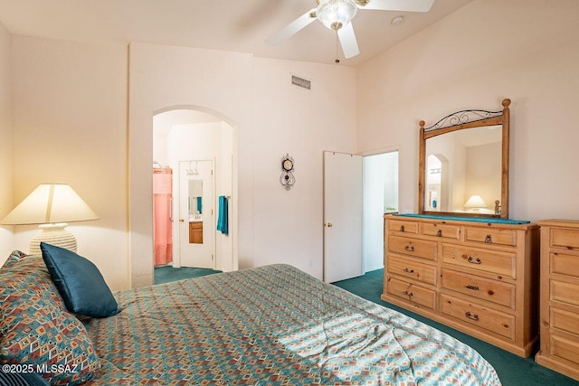 bedroom with dark carpet, ceiling fan, and ensuite bathroom