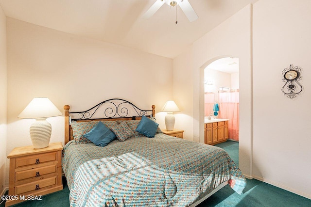 carpeted bedroom with ceiling fan, ensuite bathroom, and vaulted ceiling