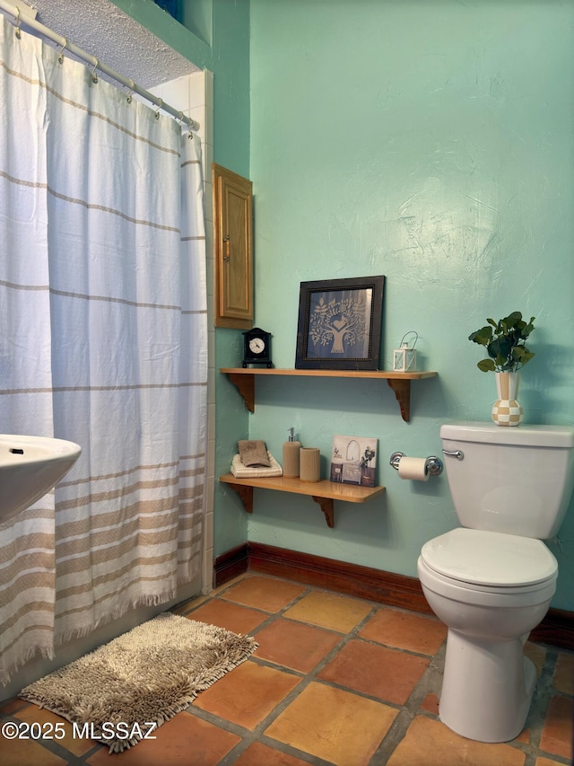 bathroom featuring toilet and walk in shower