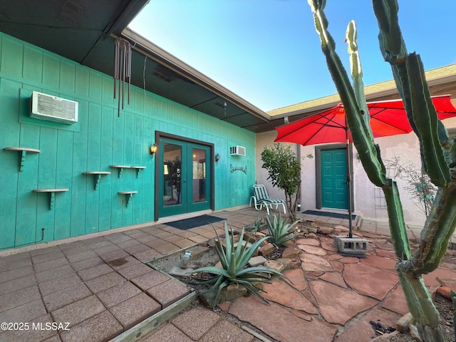 view of patio featuring french doors and a wall mounted AC