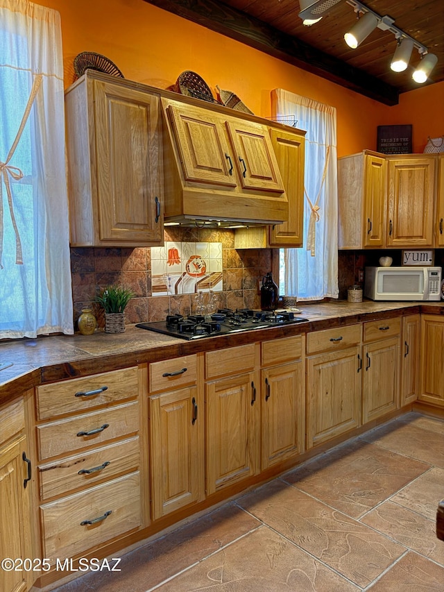 kitchen featuring tasteful backsplash, wood ceiling, black gas stovetop, and custom exhaust hood