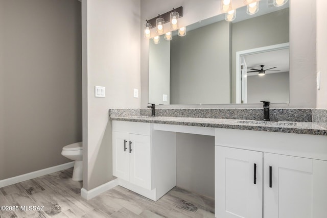 bathroom with vanity, wood-type flooring, ceiling fan, and toilet