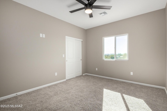 empty room featuring carpet floors and ceiling fan