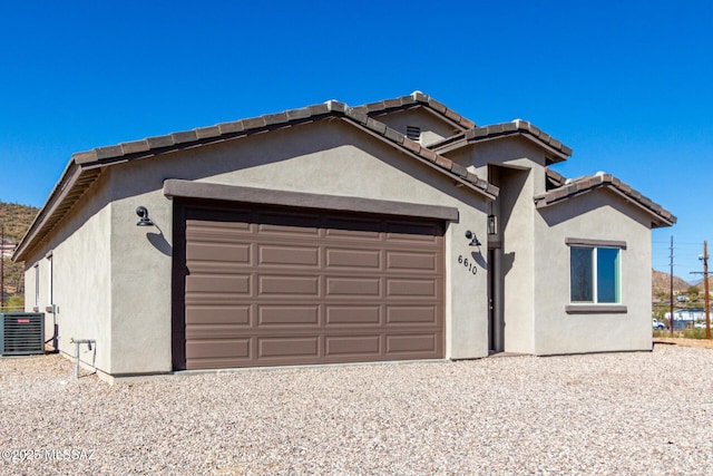 view of front of property featuring central AC unit and a garage