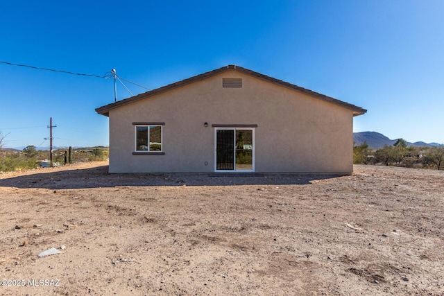 rear view of house featuring a mountain view