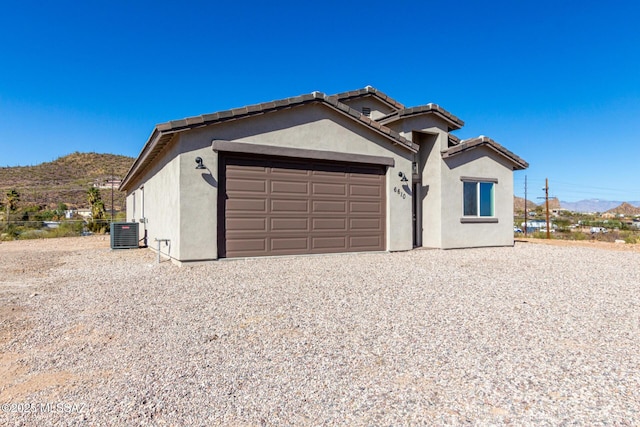 view of front of house featuring central AC, a garage, and a mountain view