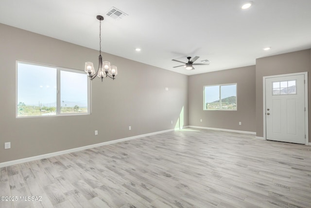 interior space featuring ceiling fan with notable chandelier and light hardwood / wood-style flooring