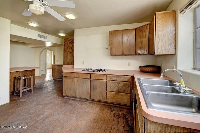 kitchen with sink, ceiling fan, gas stovetop, kitchen peninsula, and light wood-type flooring