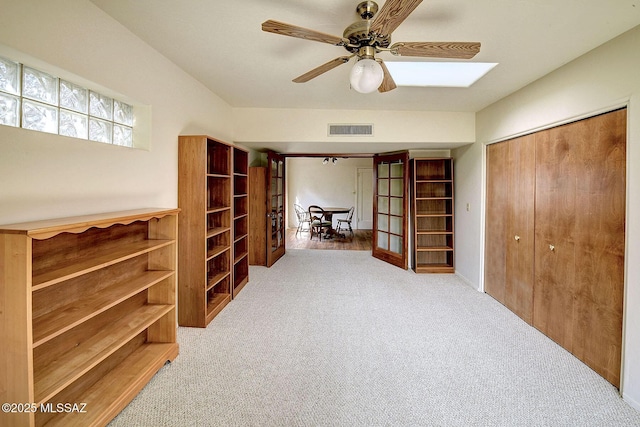 interior space with ceiling fan and light colored carpet