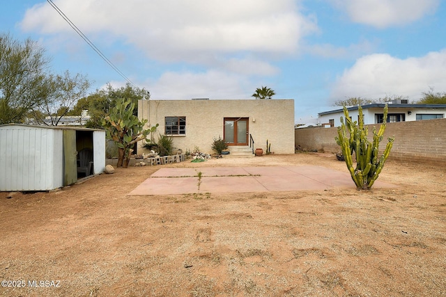 rear view of house featuring a shed and a patio