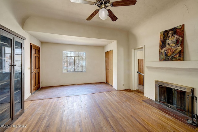 unfurnished living room featuring ceiling fan and light hardwood / wood-style floors