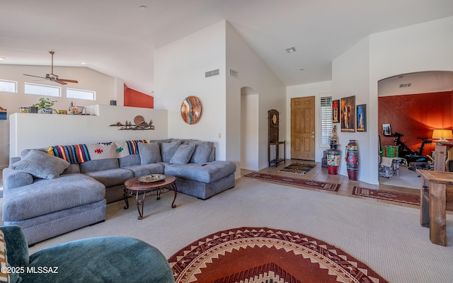 living room with ceiling fan, carpet floors, and high vaulted ceiling