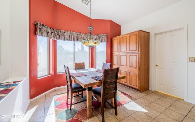 dining room featuring vaulted ceiling and light tile patterned flooring