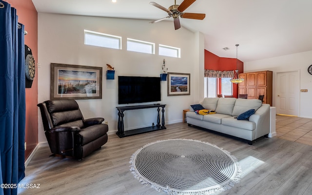 living room with ceiling fan, high vaulted ceiling, and light hardwood / wood-style flooring