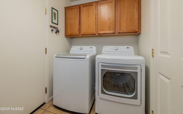 laundry room featuring cabinets, light tile patterned floors, and independent washer and dryer