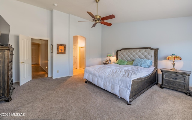 carpeted bedroom with ceiling fan and a towering ceiling