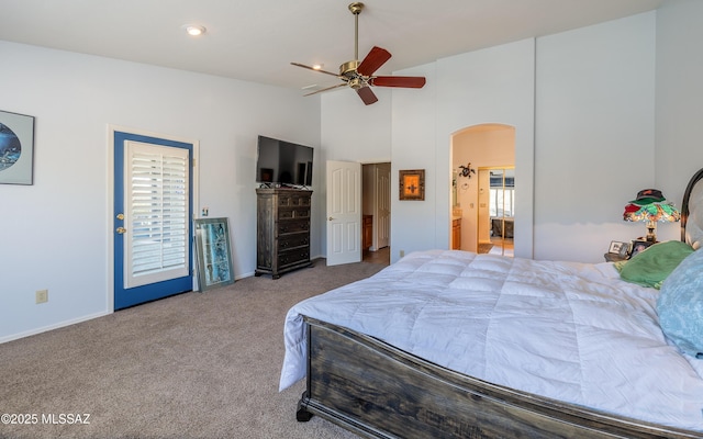 carpeted bedroom with ensuite bathroom and high vaulted ceiling