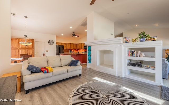 living room with light hardwood / wood-style flooring, high vaulted ceiling, and ceiling fan