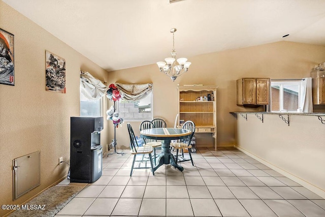 dining area with an inviting chandelier, vaulted ceiling, and light tile patterned flooring