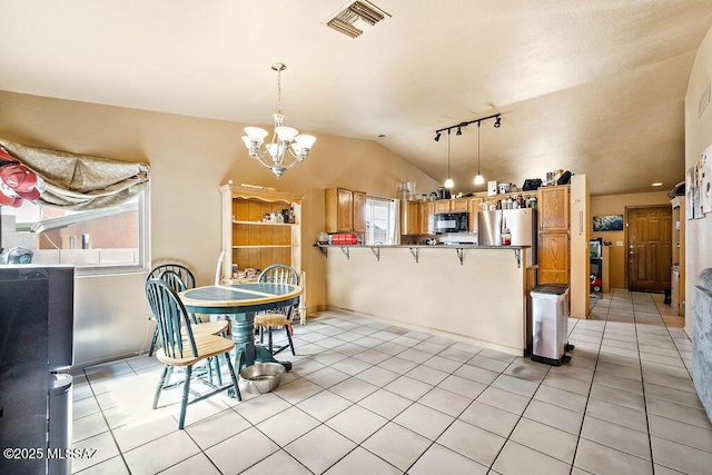 tiled dining room with lofted ceiling and a notable chandelier