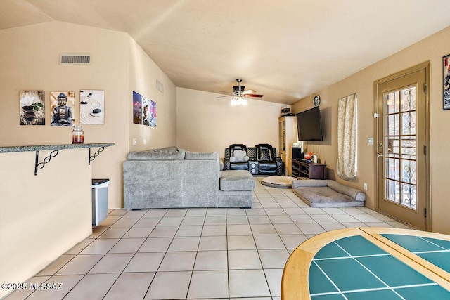 living room featuring ceiling fan, tile patterned floors, and lofted ceiling