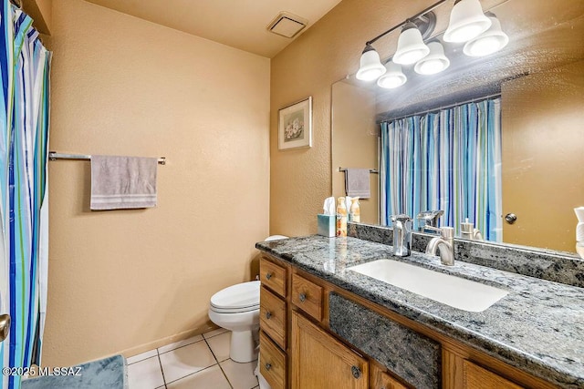 bathroom featuring tile patterned flooring, vanity, and toilet